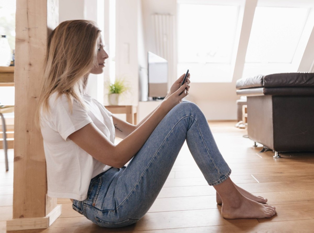 Frau mit dem Smartphone in der Wohnung