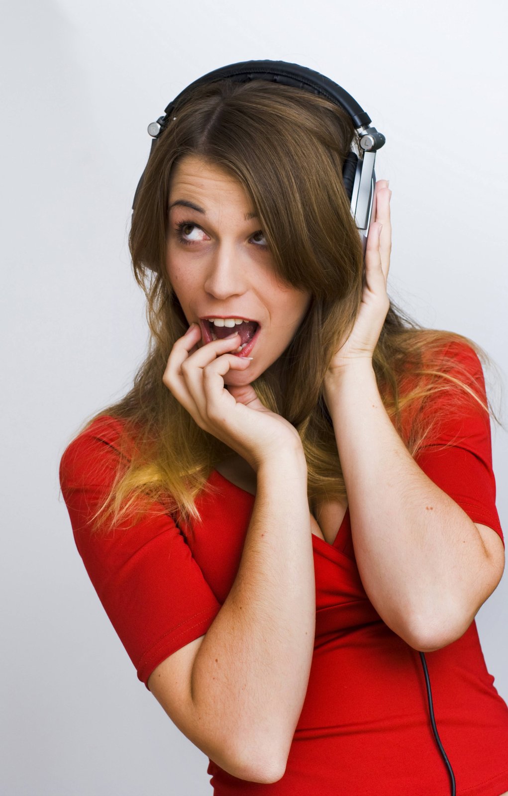 Eine Frau guckt erstaunt und hört Musik