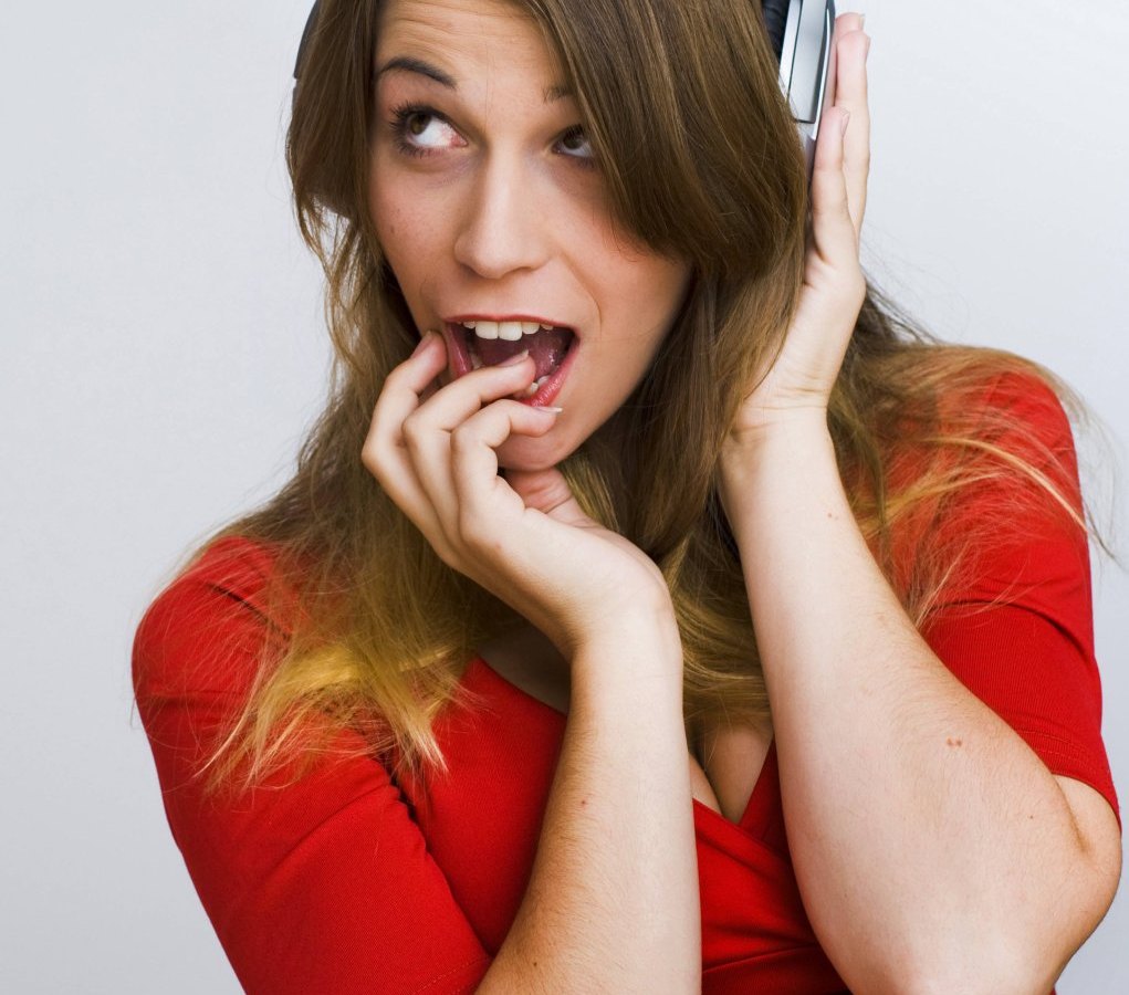 Eine Frau guckt erstaunt und hört Musik