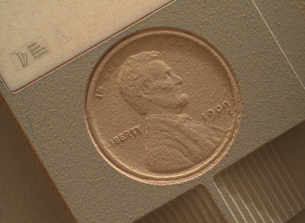 Diese amerikanische 1-Cent-Münze wurde in das Gehäuse eines Mars-Rovers integriert. Auf der Aufnahme ist die Münze von Mars-Staub bedeckt.