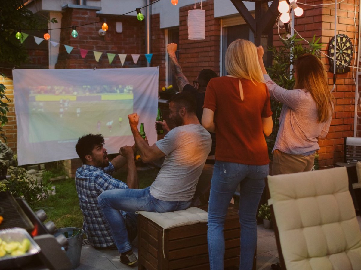 Menschen schauen mit Beamer etwas.