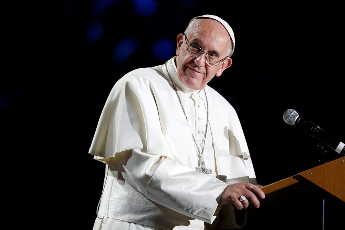 Papst Franziskus steht an einem Rednerpult.