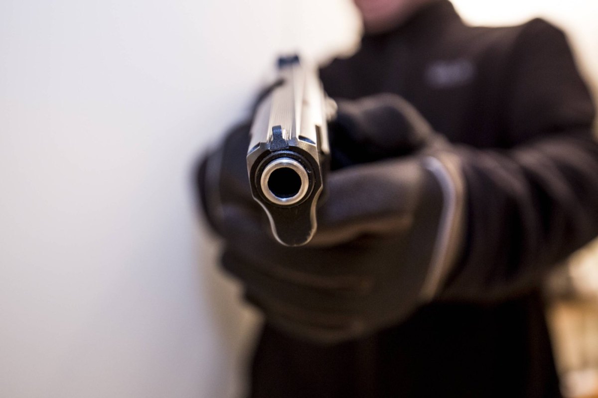 Ein Mann zückt seine Waffe