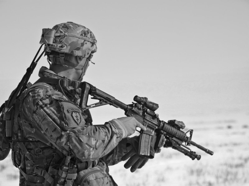 Soldat wartet mit seiner Waffe (schwarz-weiss)