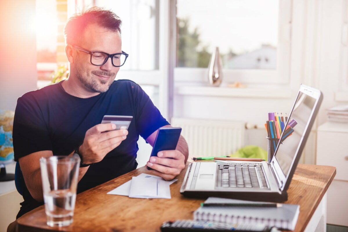 Mann gibt seine Kreditkartendaten in sein Smartphone ein