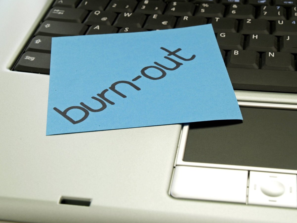 Ein Post-it mit der Aufschrift "Burn-out" auf einem Laptop