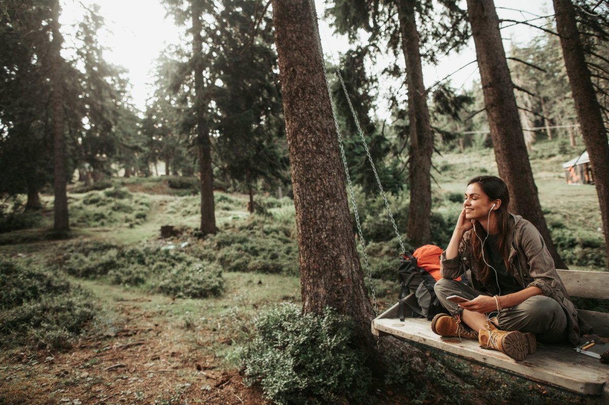 Frau mit Kopfhörern im Wald