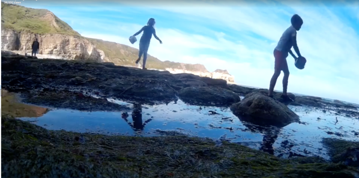 Ein Screenshot aus dem Video zeigt den Jungen und eine Freundin beim Spielen am Strand.