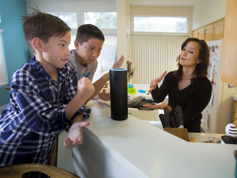 Eine Familie spricht mit einem Amazon-Lautsprecher.