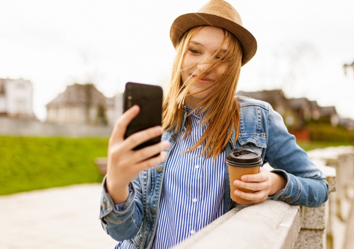 Eine Frau macht mit einem Smartphone ein Selfie.