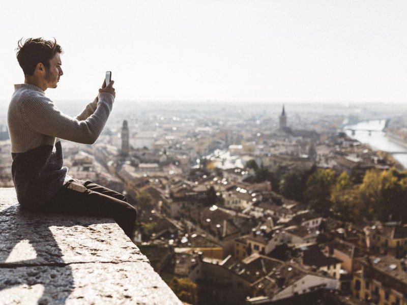 Mann fotografiert Stadt mit seinem Handy