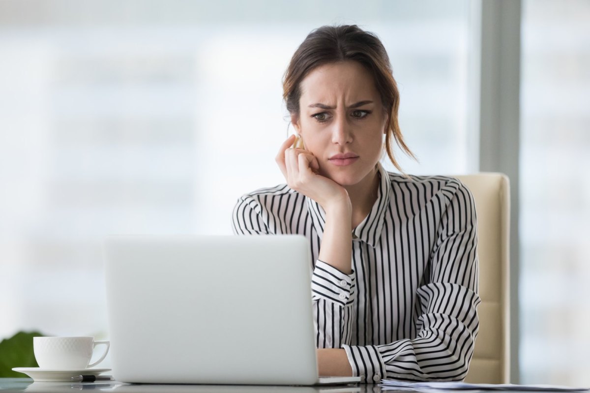 Frau sitzt skeptisch guckend vor einem Computer
