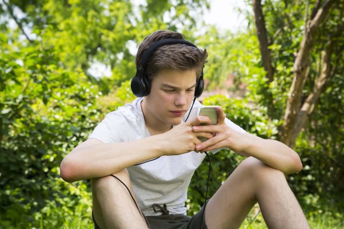Junge hört Musik in der Natur.