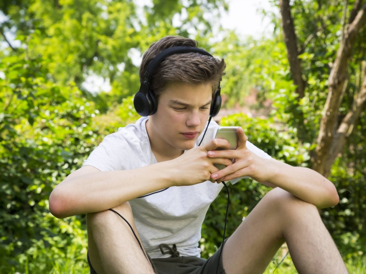 Junge hört Musik in der Natur.
