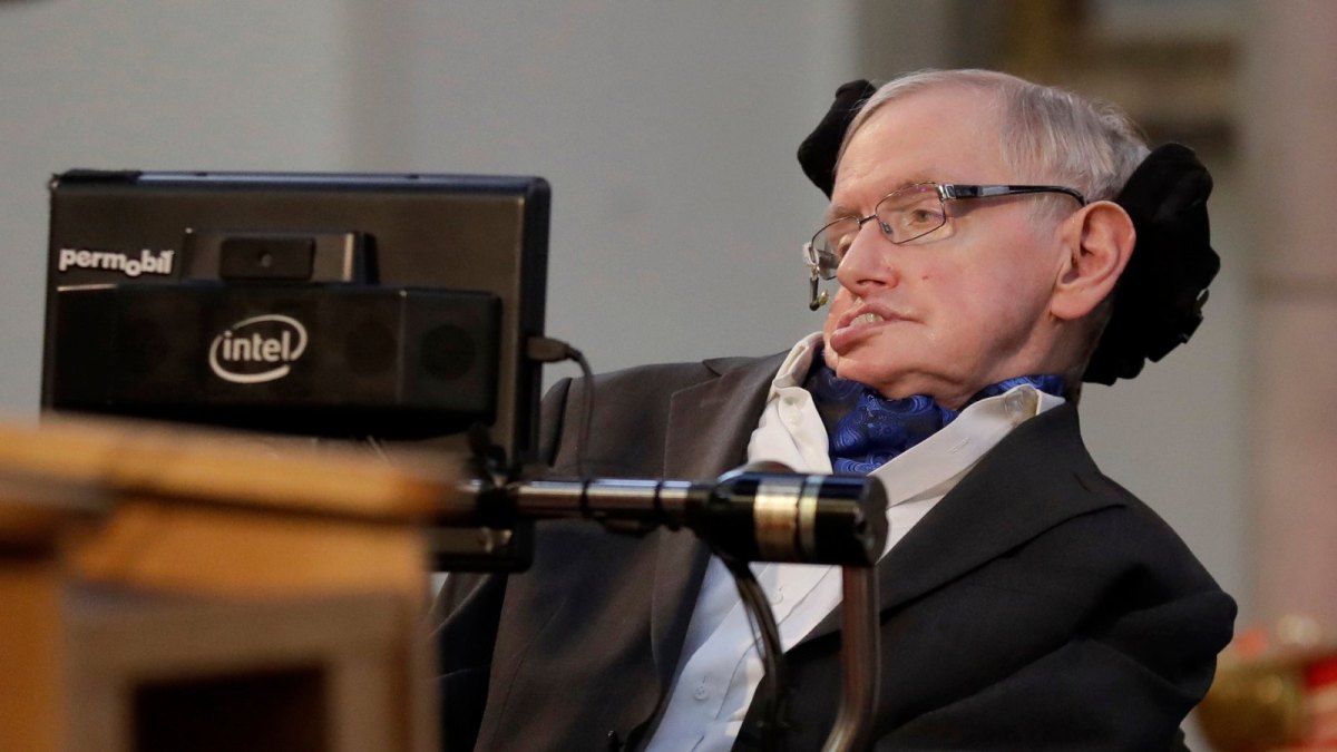 Stephen Hawking im Rollstuhl vor einem Mikrofon