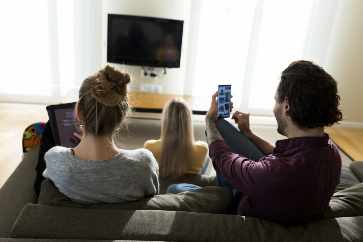 Familie sitzt gemeinsam vorm Fernseher.