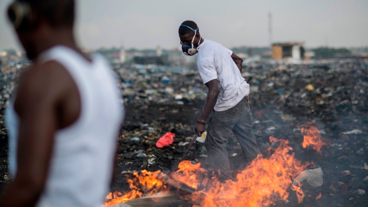 Ein afrikanischer Arbeiter mit Mundschutz auf einer Elektroschrott-Deponie.