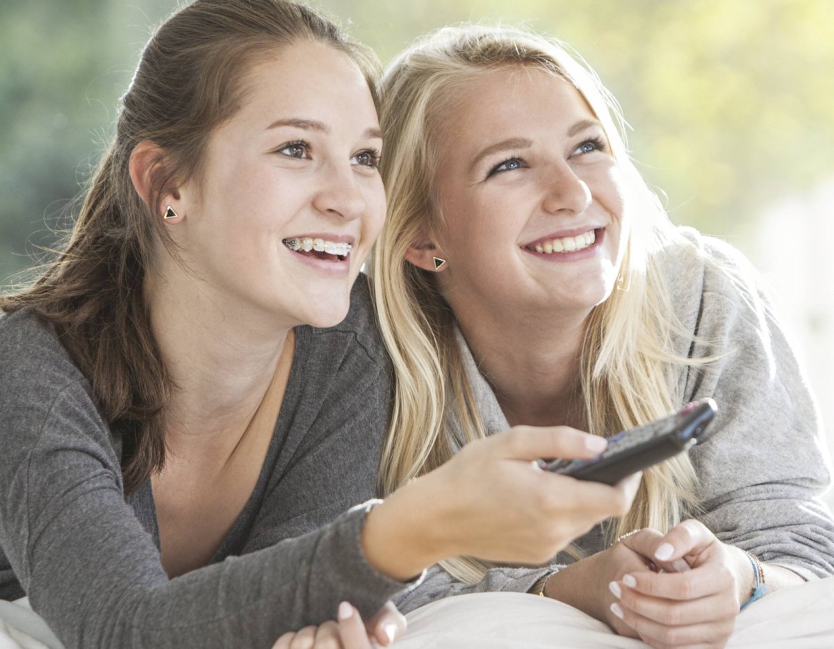 Zwei weibliche Teenager sehen fern.