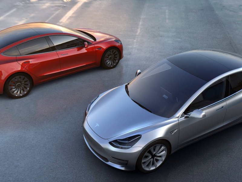 Zwei Autos des Typs Model 3 der Marke Tesla von oben fotografiert