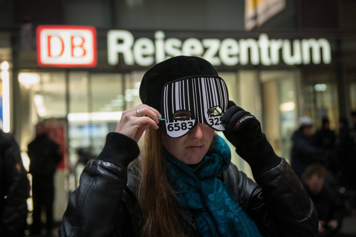 Eine Frau am S-Bahnhof Berlin-Südkreuz trägt eine Maske mit Barcode.