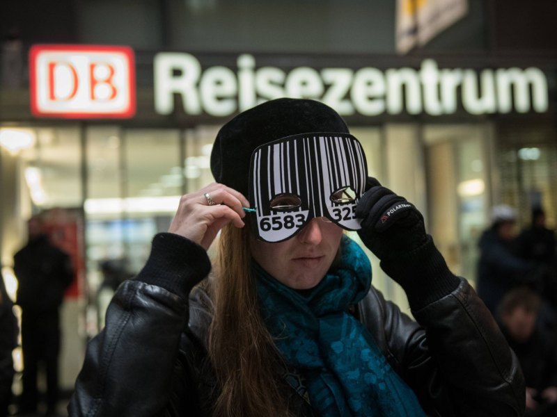 Eine Frau am S-Bahnhof Berlin-Südkreuz trägt eine Maske mit Barcode.