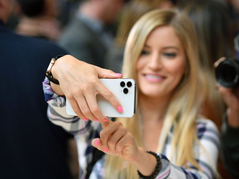 Frau macht ein Selfie mit dem iPhone 11.