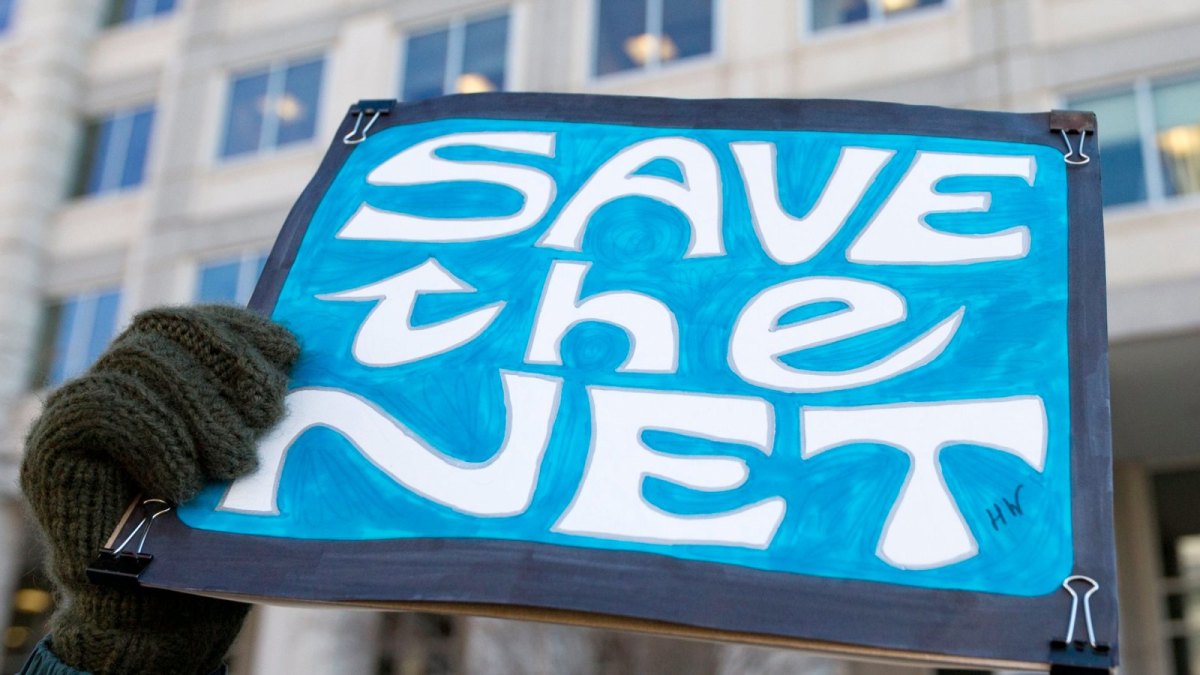 Ein Demonstrant hält ein Schild mit dem Titel "Save the Net" hoch.