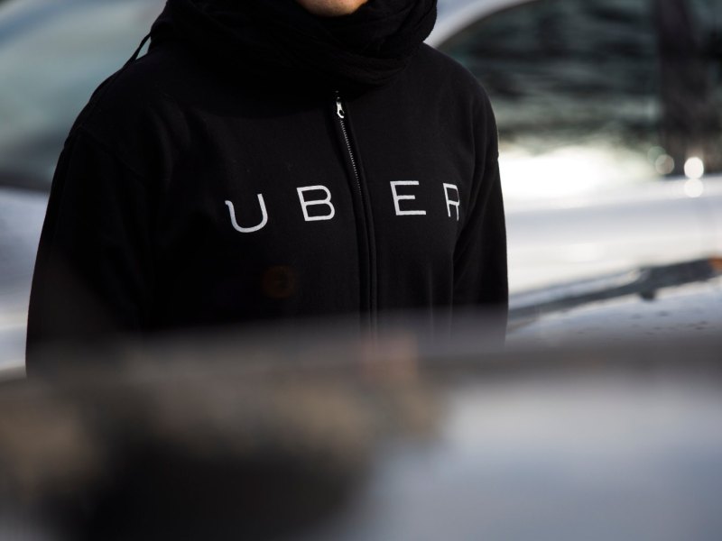 Ein Mann trägt eine Kapuzenjacke mit dem Uber-Logo darauf.