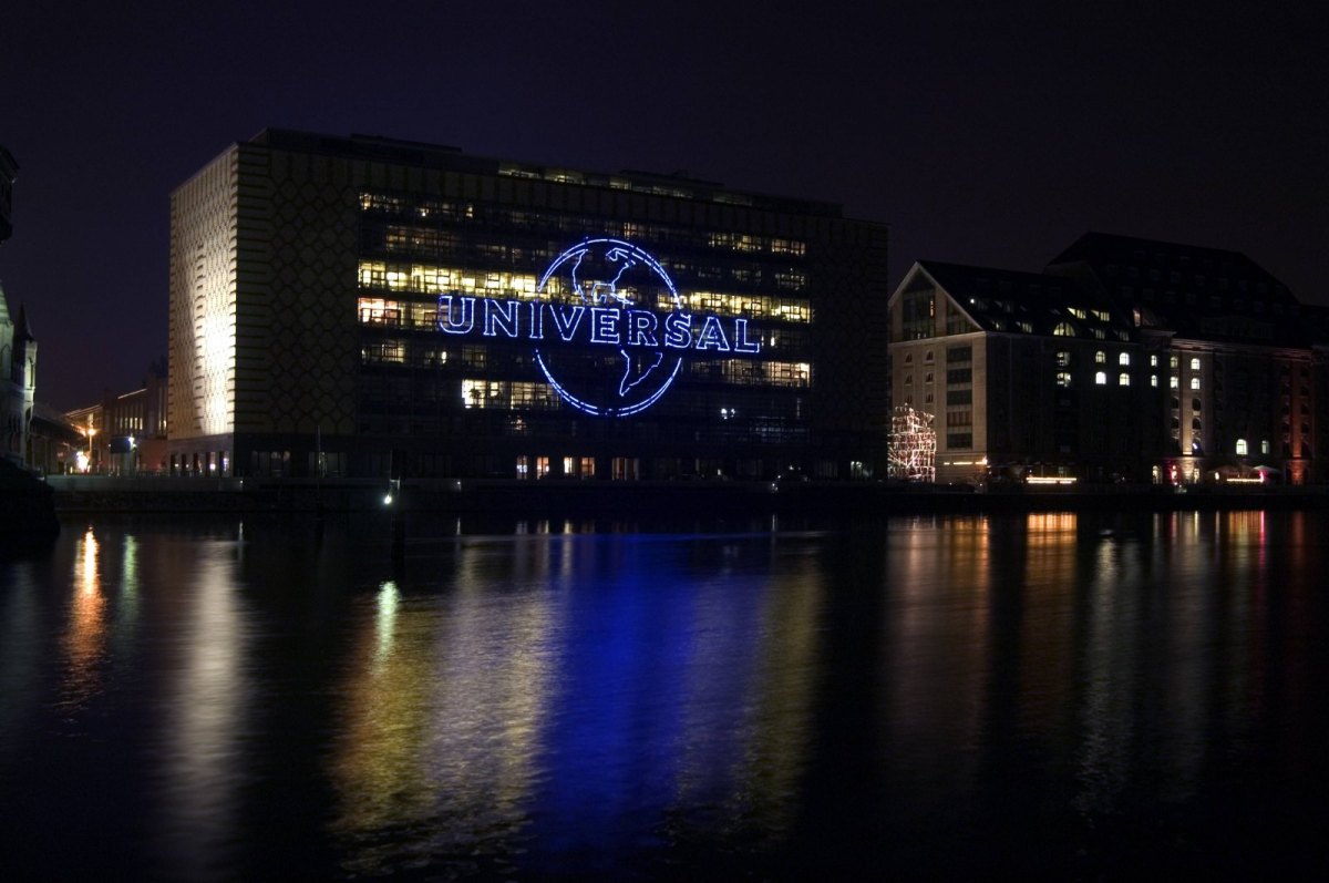 Das Universal Music Logo am Bürogebäude in Berlin leuchtet nachts.