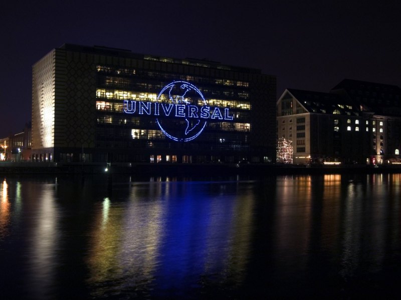 Das Universal Music Logo am Bürogebäude in Berlin leuchtet nachts.