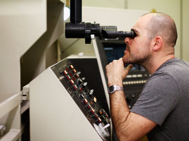 Ein Forscher blickt durch ein Miskroskop.
