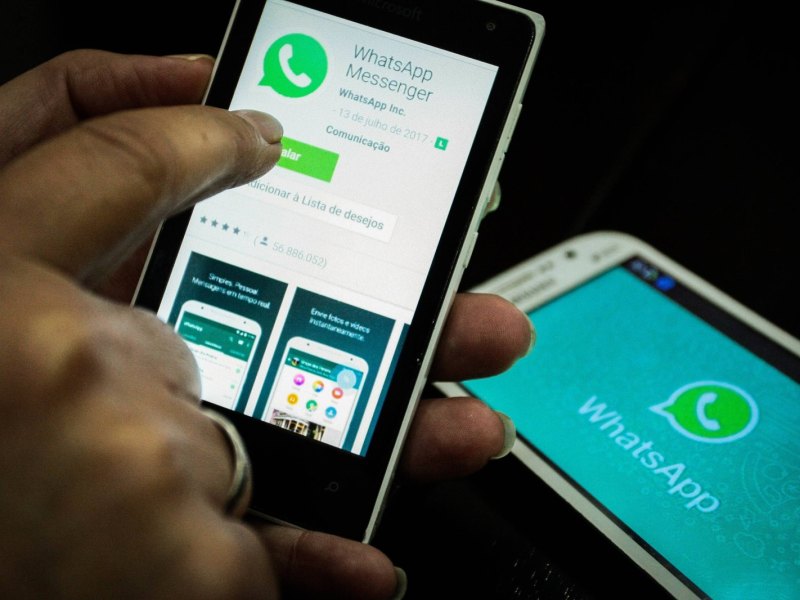 Hand hält Handy mit WhatsApp-Messenger-Installation