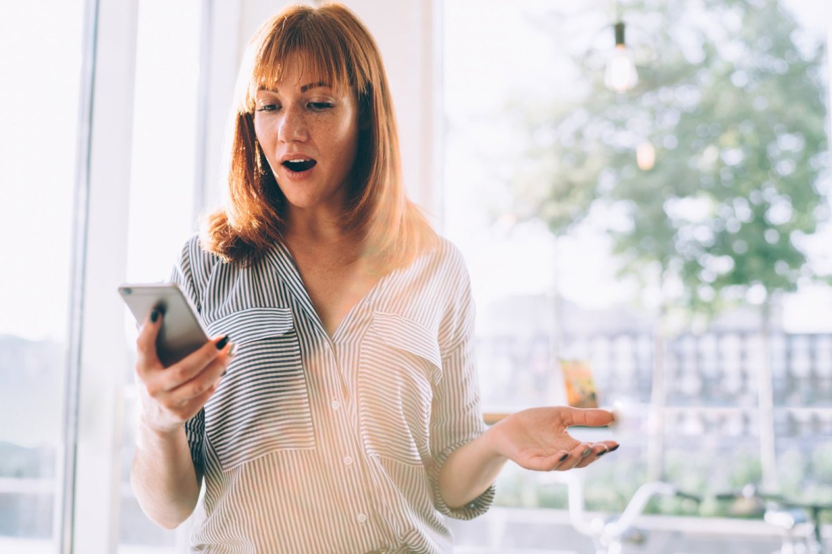 Frau am Handy schockiert