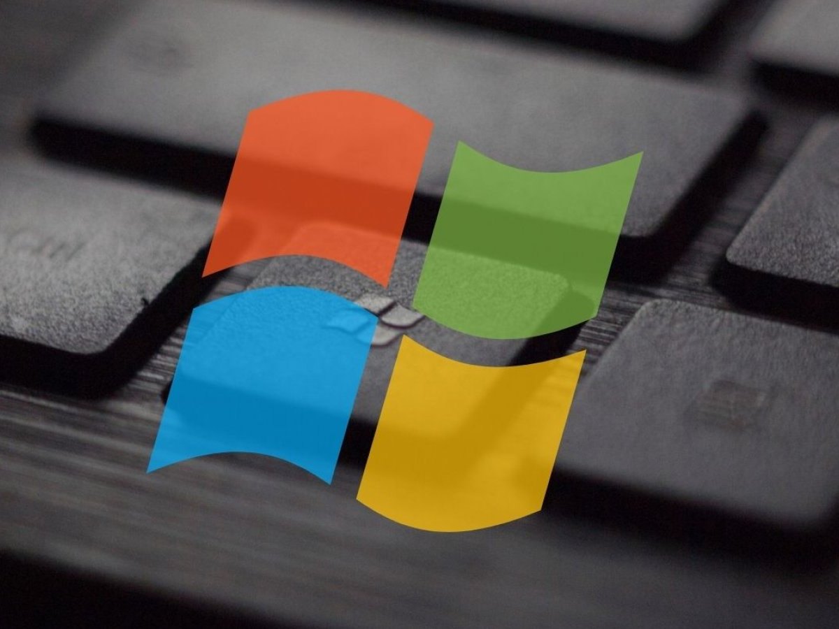 Ein Ausschnitt einer Tastatur. Davor ein buntes Windows-Logo.