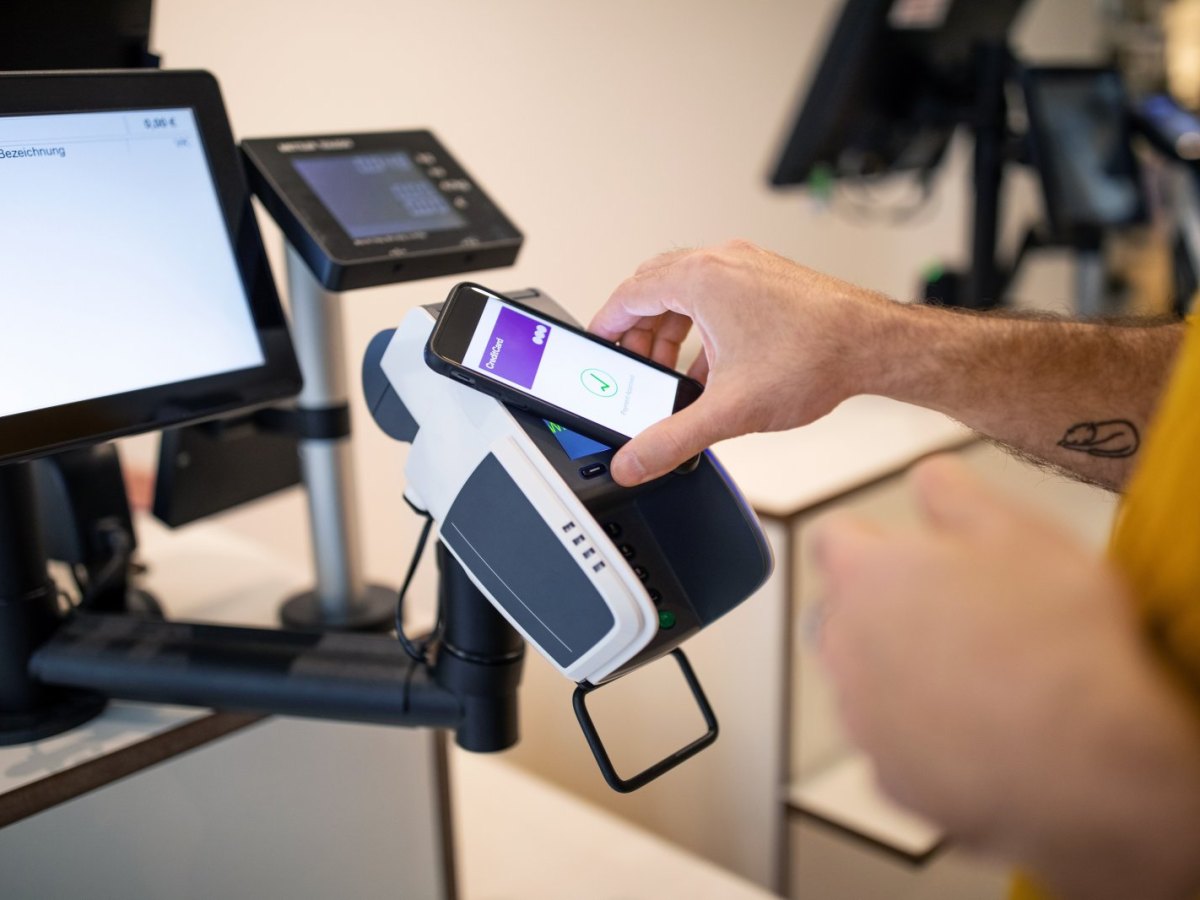 Person zahlt kontaktlos mit dem Handy