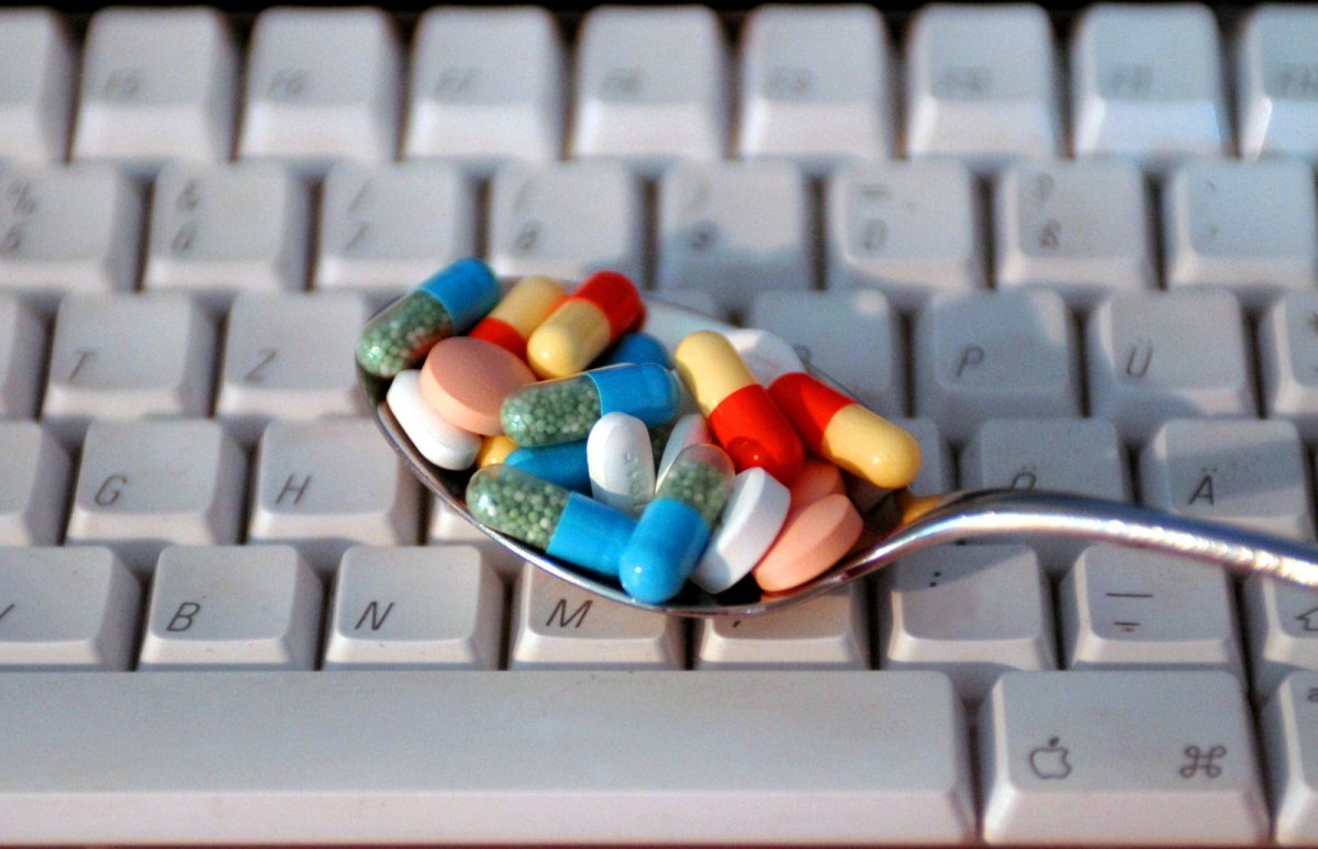 Löffel mit Pillen auf einer Tastatur