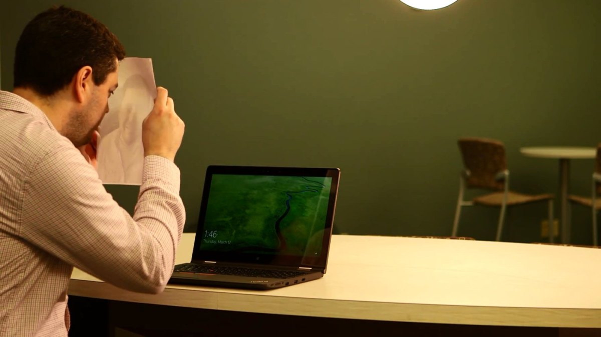 Ein Mann sitzt vor einem Microsoft Laptop.