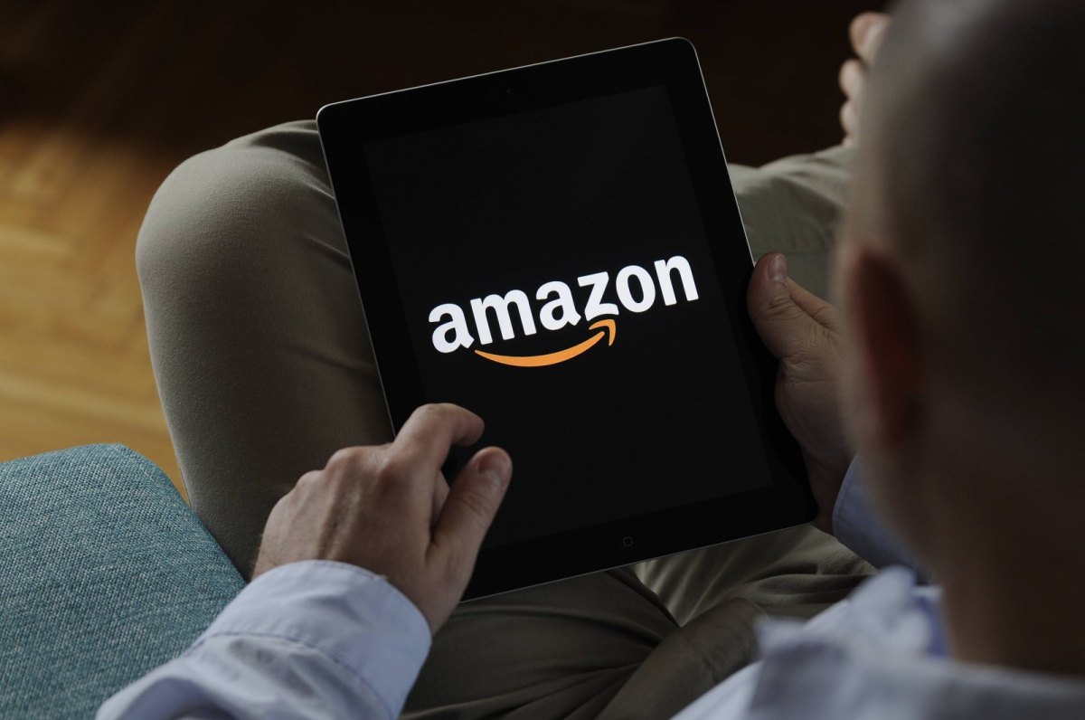 Ein Mann mit einem iPad in der Hand. Auf dem iPad ist das Amazon-Logo zu sehen.
