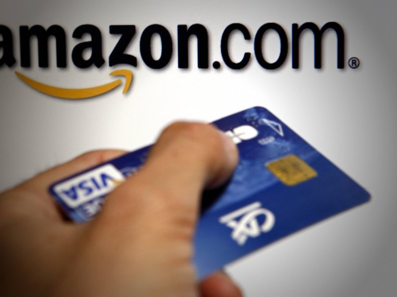 Eine Kreditkarte vor dem Amazon Logo.
