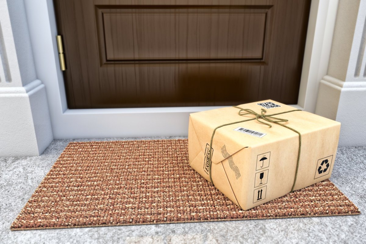 Ein Paket liegt auf dem Boden vor der Haustür.