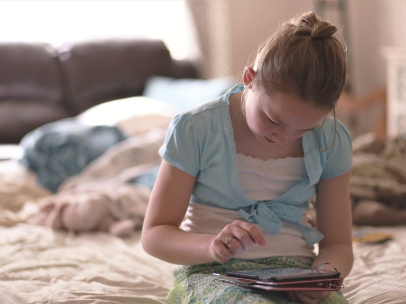 Mädchen sitzt am Tablet