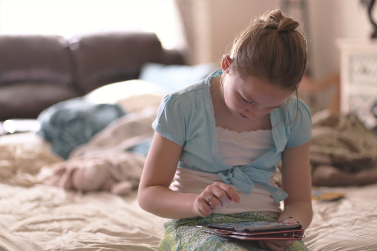 Mädchen sitzt am Tablet