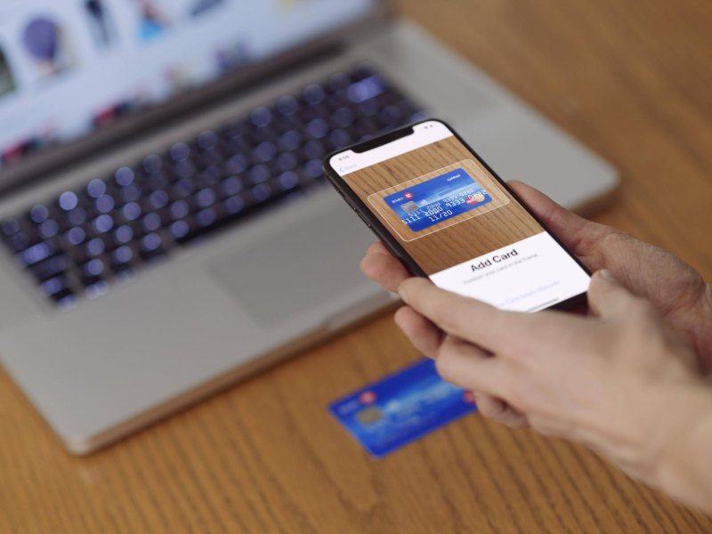Person scannt Kreditkarte mit iPhone ein