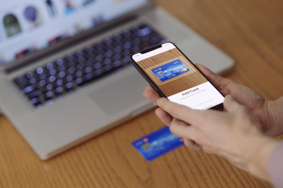 Person scannt Kreditkarte mit iPhone ein