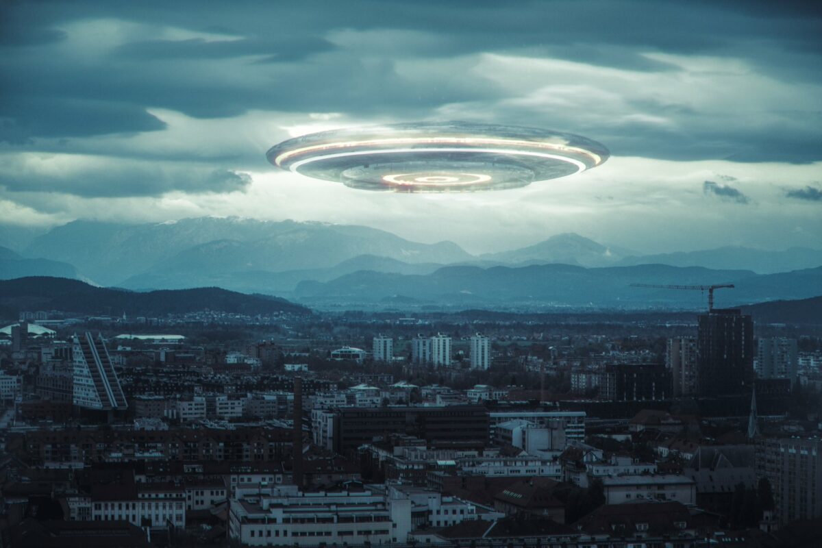 Ein UFO schwebt über einer Stadt.