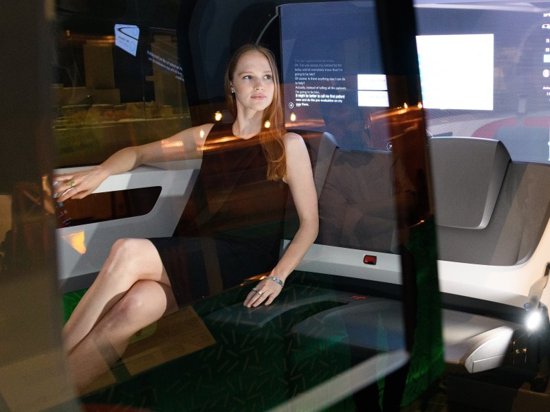 Frau sitzt in autonomem Fahrzeug