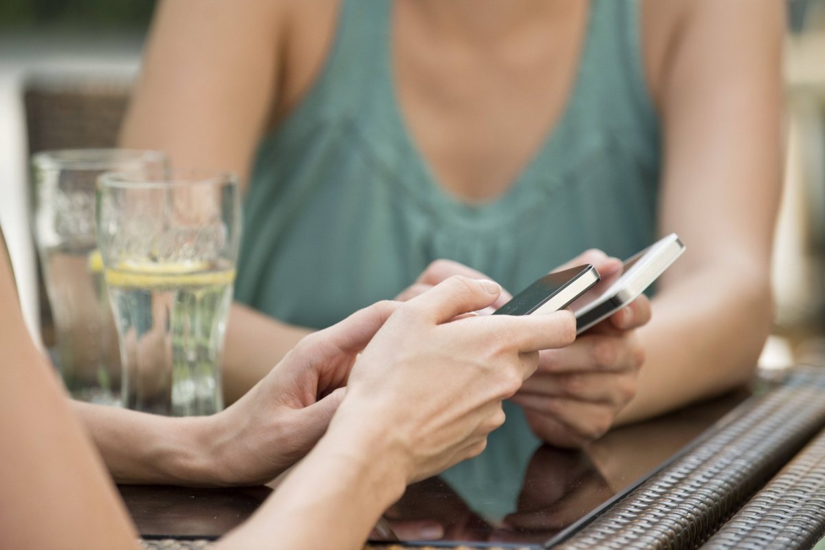 Frauen verbinden Handys per Bluetooth