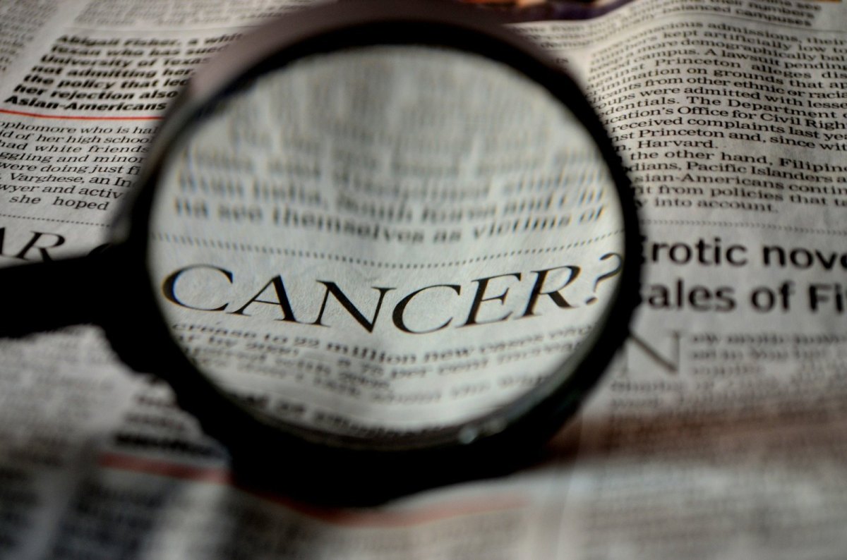 Ein Zeitungartikel über Krebs wird durch eine Lupe lesbar