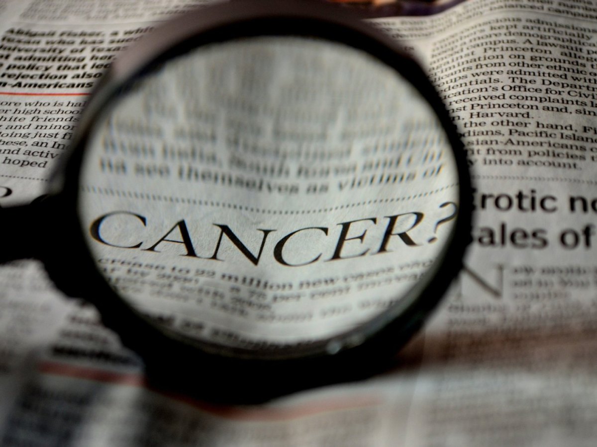 Ein Zeitungartikel über Krebs wird durch eine Lupe lesbar