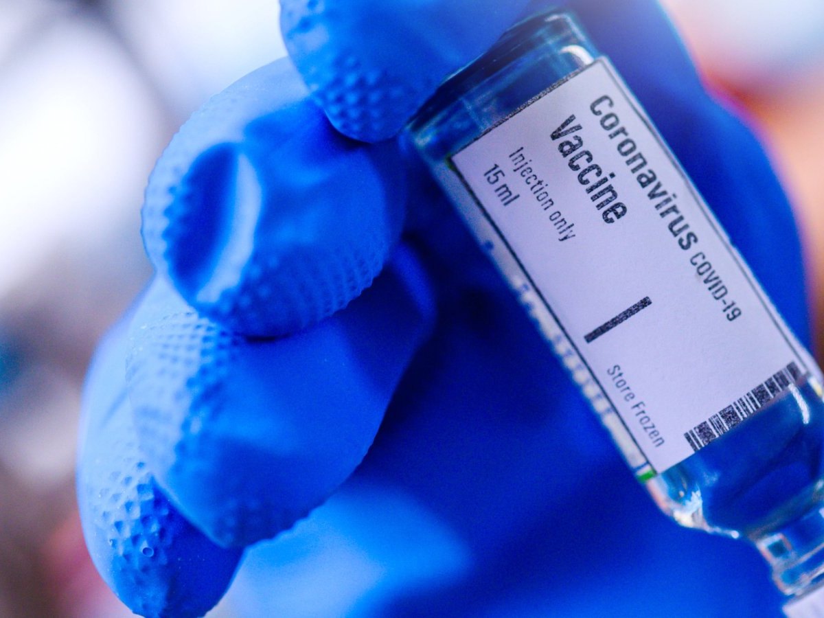 Hand hält Coronavirus-Impfstoff